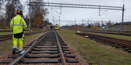 Högupplöst bild av "Järnvägstekniker i varselkläder promenerar längs järnvägsspåret", visa i nytt fönster