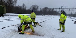 Högupplöst bild av "Bantekniker övar på att kapa järnvägsspår i snölandskap", visa i nytt fönster