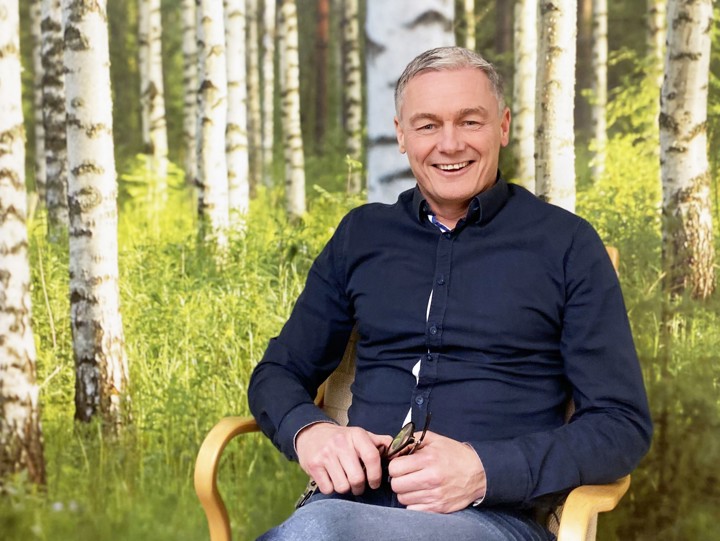 Tony Helm framför en vägg med björkskog.